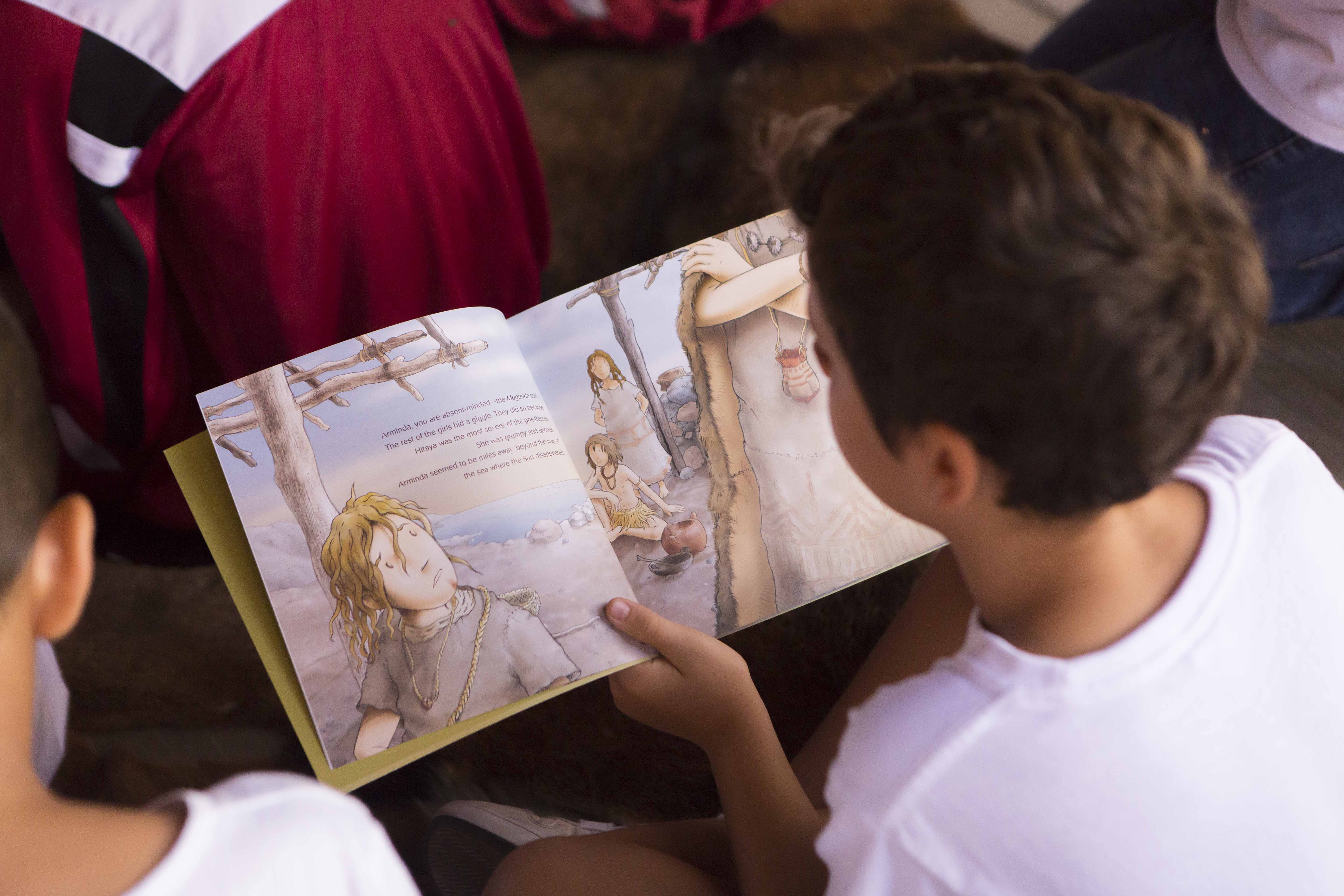 Un niño lee la versión inglesa de Arajelbén
